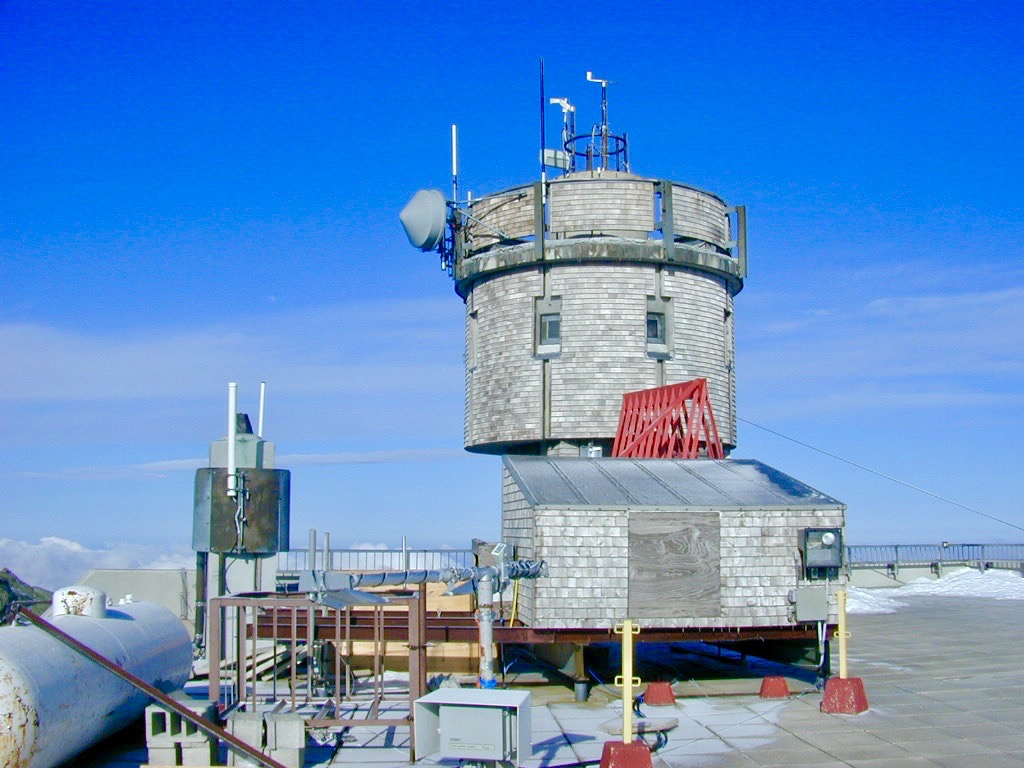 The observatory tower and rooftop weather instruments under a deep blue winter sky.